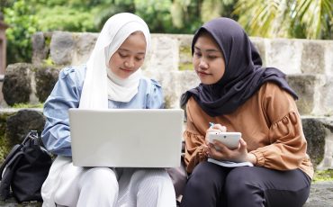 two Asian woman student friends discussing
