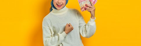 Cheerful beautiful asian woman in white sweater and hijab showin