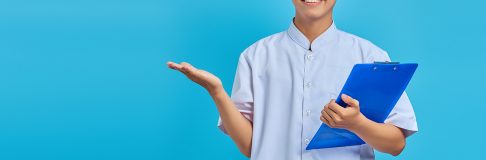Portrait of cheerful male nurse holding clipboard and pointing s